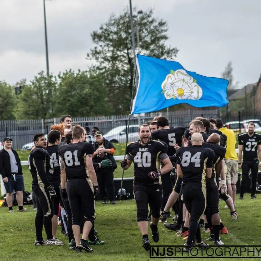 Adam Cowley runs through two lines of players with a Yorkshire flag