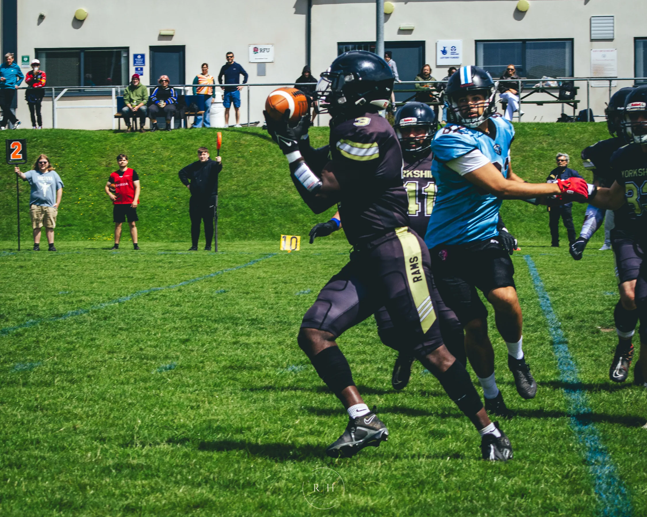 A Rams receiver hauls in a catch under pressure from the Giants defence